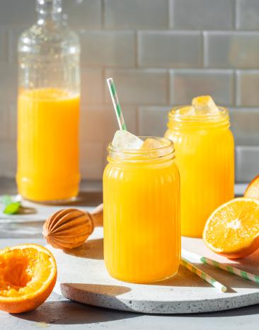 Mango-Orangen-Limonade in Gläsern mit Eis und Strohhalm. Mango-Orangen-Limonade in Gläsern mit Eis und Strohhalm.