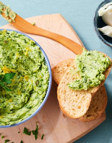 Zitronenbutter mit Kräutern in einer Schüssel.