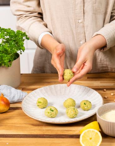 Falafelmasse mit den Händen zu kleinen Bällchen formen. Falafelmasse mit den Händen zu kleinen Bällchen formen.