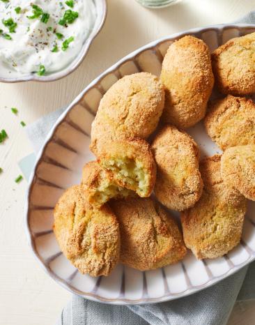 Kroketten mit Zucchini auf einem Teller mit Dip.
