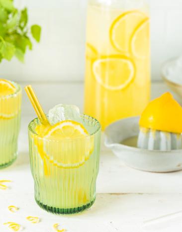 Zitronenlimonade mit Zitronenscheiben und Strohhalm in Gläsern.