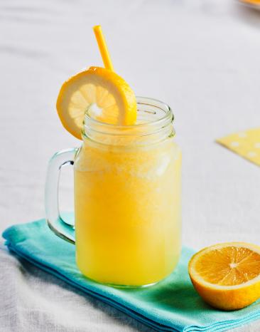 Spritzige Zitronen-Granita in einem Glas mit Strohhalm.