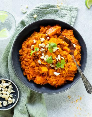 Linsen Dal mit Kürbis in einer dunklen Schüssel.