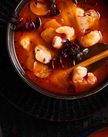 Garnelensuppe mit rotem Currysud in einer Schüssel.