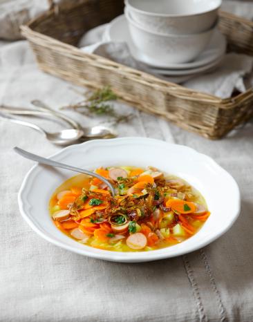 Karotteneintopf mit gerösteten Zwiebeln auf einem gedeckten Tisch.