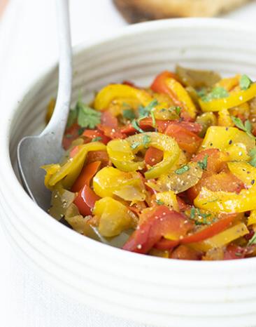 Paprika süß-sauer mit einem weißen Löffel in einer weißen Schale.