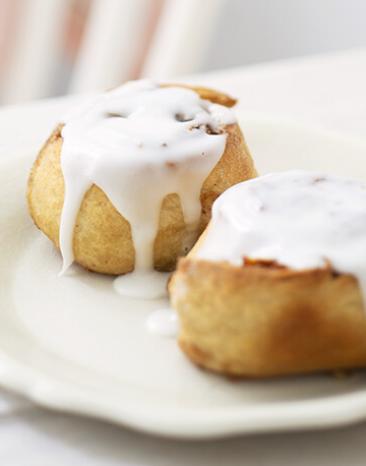 Zimt-Walnuss-Schnecken mit Zuckerguss auf einem Teller.