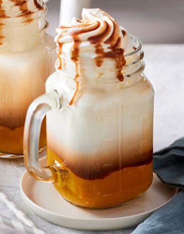 Pumpkin Spice Latte in Gläsern mit Griff und Sahne oben drauf.