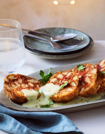 Rote Bete Knödel aufgeschnitten auf einer Servierplatte.