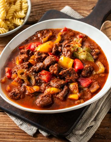 Buntes Paprikagulasch in tiefem Teller mit Nudeln