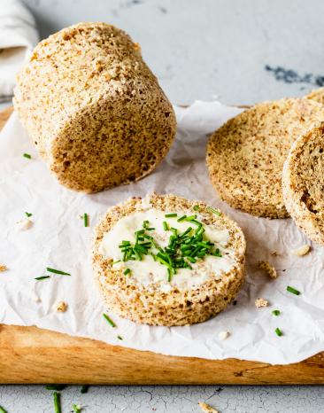 Low Carb Brot aus der Tasse in Scheiben geschnitten mit Butter und Kräutern.