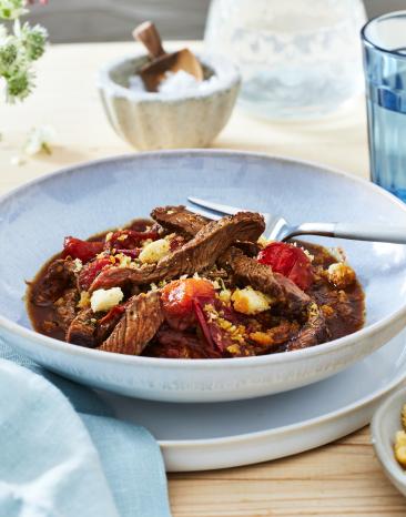 Streakstreifen mit Tomate in einem tiefen Teller angerichtet.