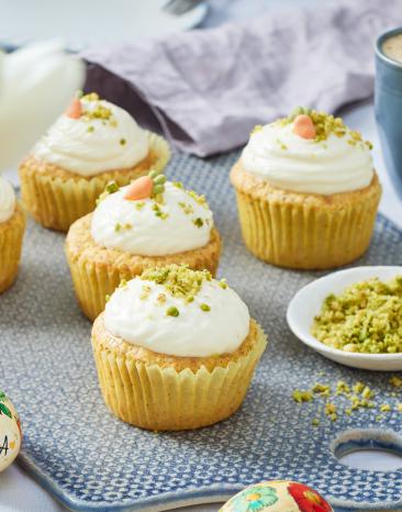 Carrot Cake Cupcakes mit Schmandcreme und Pistazien getoppt.