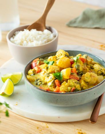 Mango Curry mit Hähnchen in einer Schale, daneben Reis.