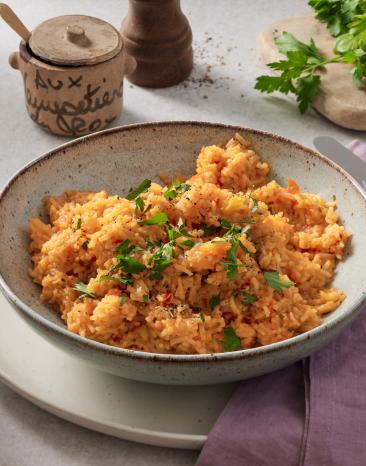 One Pot Reis mit Paprika in einem Teller mit frischen Kräutern