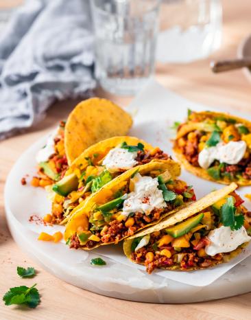 Tacos mit Hackfleisch und Mango Salsa auf einem Teller.