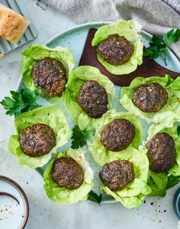 Köfte in Salatblättern auf einem Teller.