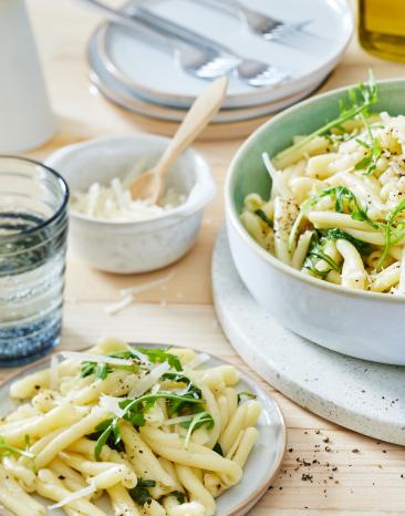 Zitronenpasta mit frischen Kräutern in einem tiefen Teller.