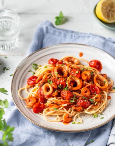 Spaghetti Frutti di Mare in einem tiefen Teller mit frischen Kräutern.