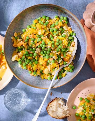 Erbsensalat in einem tiefen Teller mit einem großen Löffel.