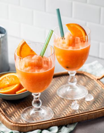 Aperol Slush mit Orangenscheiben in zwei Gläsern. Aperol Slush mit Orangenscheiben in zwei Gläsern.