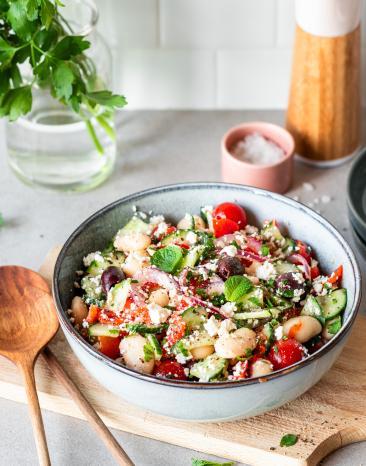 Griechischer Bohnensalat mit Feta und Kirschtomaten in einer Schüssel.