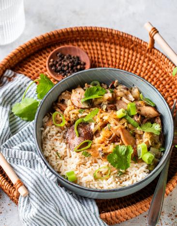 Asiatisches Pilzpfannengericht in einer Schüssel mit Essstäbchen.