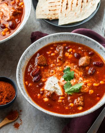 Mexikanischer Bohneneintopf mit Brot in Schüsseln.