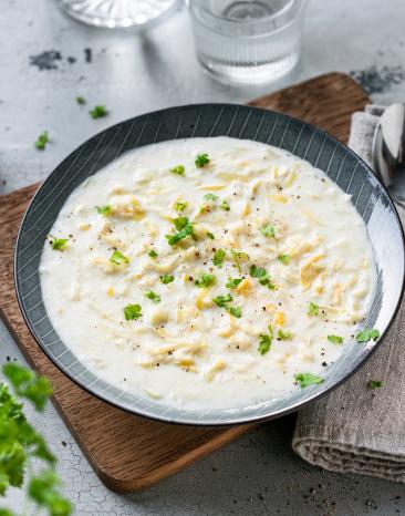 Käse-Lauch-Suppe in einer dunklen Schüssel.