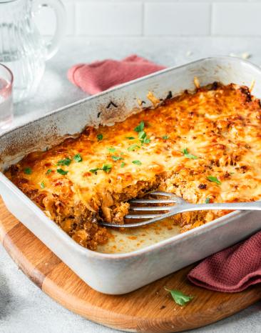 Weißkohlauflauf mit Käse überbacken in einer weißen Auflaufform.