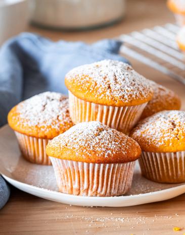 Kürbis-Muffins auf einem Kuchengitter mit Puderzucker bestäubt.