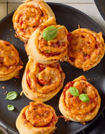 Vegane Pizzaschnecken mit Basilikum garniert.