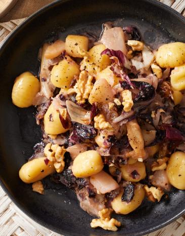 Gnocchi mit Birne und Gorgonzola in dunklen Tellern.