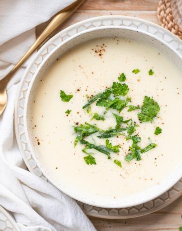Schnelle Kohlrabicremesuppe mit Kräutern in hellen Schalen.