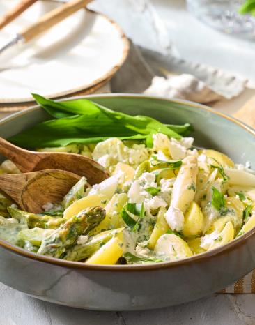 Kartoffelsalat mit Spargel und Bärlauch in einer Salatschüssel.