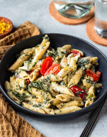 One-Pot-Pasta mit Spinat in einem schwarzen tiefen Teller