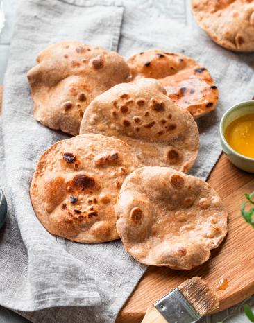 Chapatis (Indisches Fladenbrot) luftig ausgebacken auf einem Tuch.