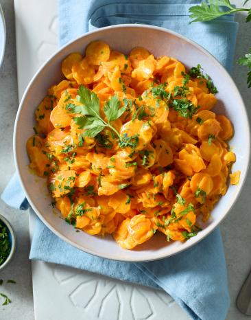 Cremiges Karottengemüse in einer Schüssel mit Petersilie.