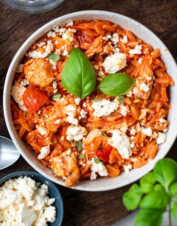 One-Pot-Kritharaki mit Feta und Hähnchen in Schüsseln.