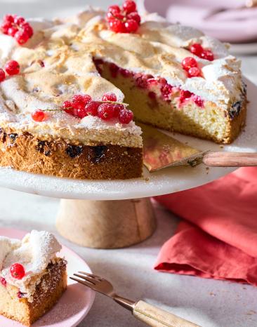 Johannisbeerkuchen mit Baiser auf einer Tortenplatte.