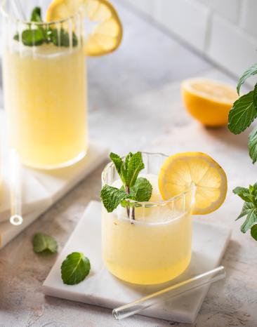 Schneller sommerlicher Limoncello Slush mit Minze und Zitrone garniert in Gläsern.