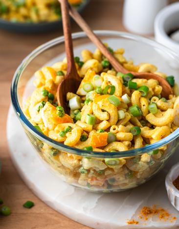 Curry Nudelsalat in einer Glasschale.