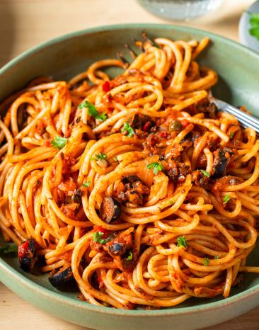 Pasta alla puttanesca mit Spaghetti in tiefen Tellern.