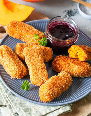 Kürbiskroketten auf einem Teller mit Dip