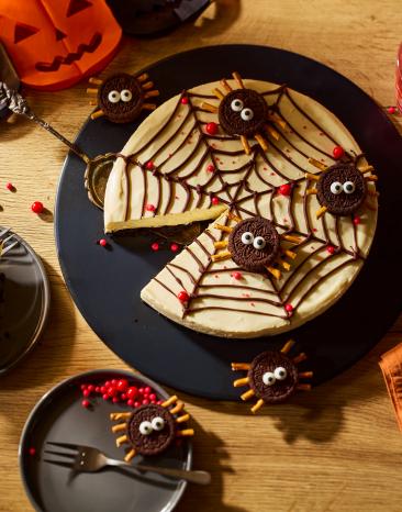 Spinnennetz No-Bake-Cheesecake auf einem gedeckten Halloween-Tisch