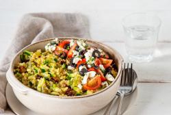 Zucchini-Bulgur mit Feta und Tomaten in Schüssel mit Besteck