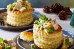 Hübsch dekorierte Pasteten auf dunlen Tellern auf einem festlichen Tisch.